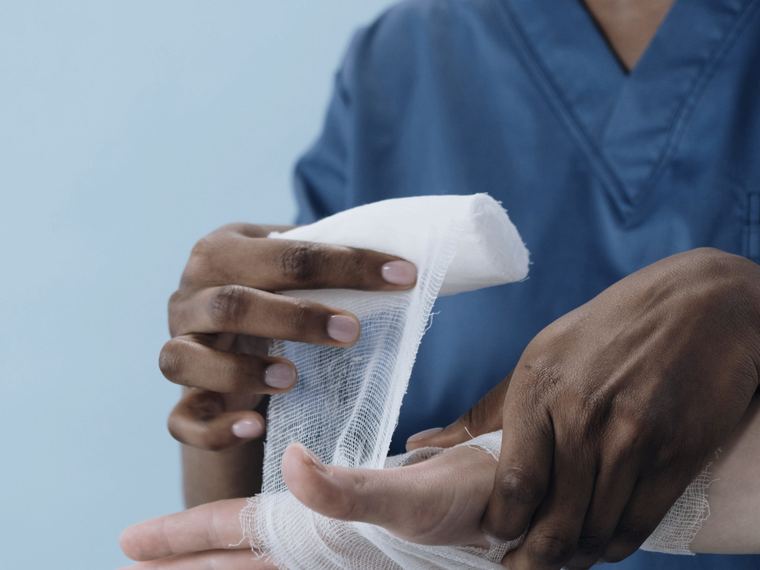 A clinician wrapping an injured hand