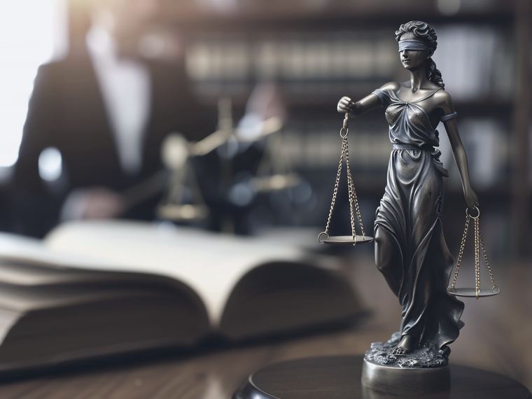 Scales of justice beside an open law book